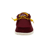 The front view of a maroon HEYDUDE shoe with yellow laces.