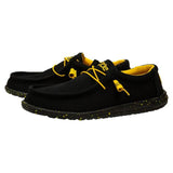 A pair of black HEYDUDE shoes with a yellow insole and laces. One of the shoes is positioned behind the other one.