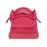 A reddish pink shoe pictured from the front angle. The shoe features a HEYDUDE logo on the tongue.