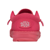 A reddish pink shoe from the back. There is a patch on the shoe containing HEYDUDE's logo.