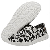 A pair of black and white cow print shoes on a white background.