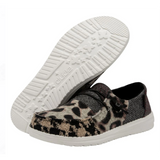 A pair of HEYDUDE shoes featuring a leopard and neutral patchwork pattern. One of the shoes is angled to where you can only see the white outsole.