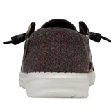 A back view of a HEYDUDE shoe atop a white background. The back portion is a dark gray color with a subtle red dot pattern.